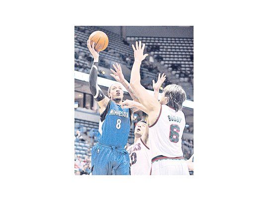 Carlos Delfino y Andrew Bogut intentan tapar a Michael Beasley, de los Timberwolves. El argentino cumplió una gran labor en el triunfo de los Bucks.