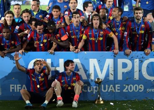 Messi cuida la copa mientras sus compañeros posan para la foto.
