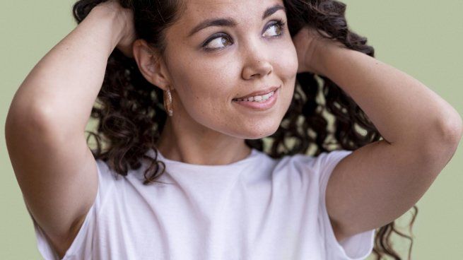 mujer-rizada-sosteniendo-su-cabello-en-estudio