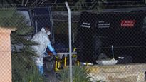 La policía forense retira uno de los cuerpos de la vivienda de Elche, Alicante.