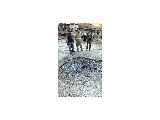 Fuerzas iraquíes realizan controles en la zona y observan el cráter dejado por la explosión del coche bomba