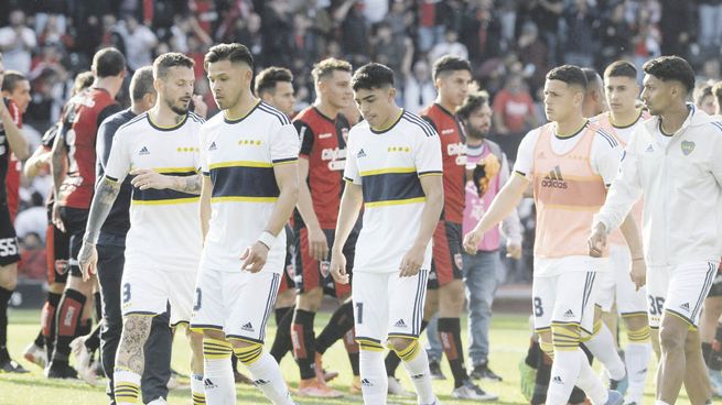 Las dos caras. Atrás, los jugadores de Newell’s festejan el triunfo sobre el líder, adelante, los de Boca se retiran con caras de preocupación. Con la derrota el Xeneize quedó apenas a 1 punto de Racing.