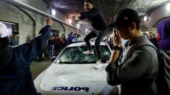 Un hincha de Toronto Raptors trepado a un patrullero de la policía durante los festejos por el título de la NBA.