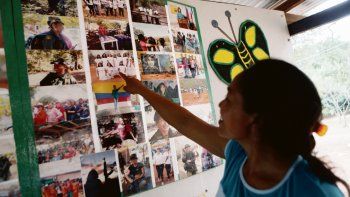 PASADO. Kelly Martínez enseña fotografías de sus años como miembro de las FARC en un campamento de reintegración en Tierra Grata.