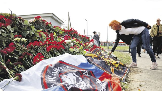 HOMENAJES. Una mujer deja una ofrenda en un altar improvisado en homenaje a Yevgueni Prigozhin, líder del grupo paramilitar Wagner, en San Petersburgo.
