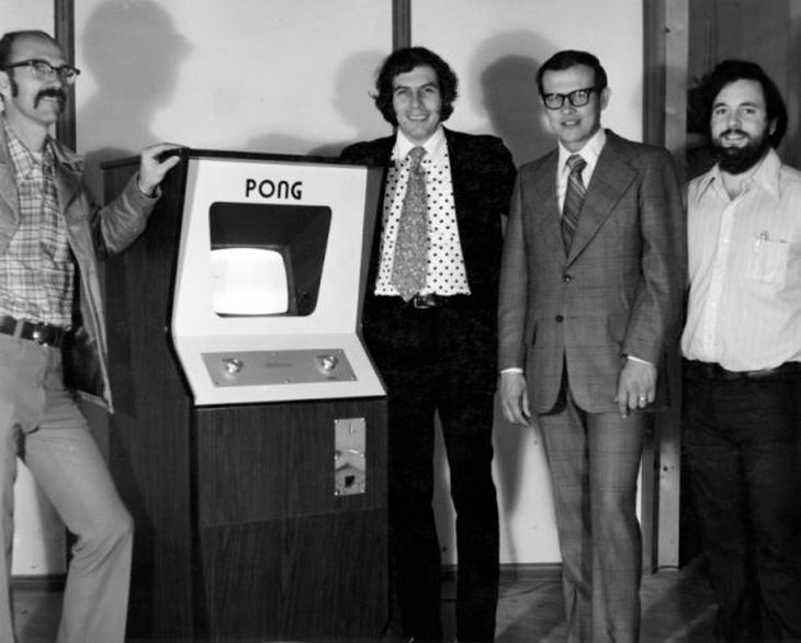Los fundadores y desarrolladores de Atari con la primera versión del arcade Pong, basado en el tenis de mesa.
