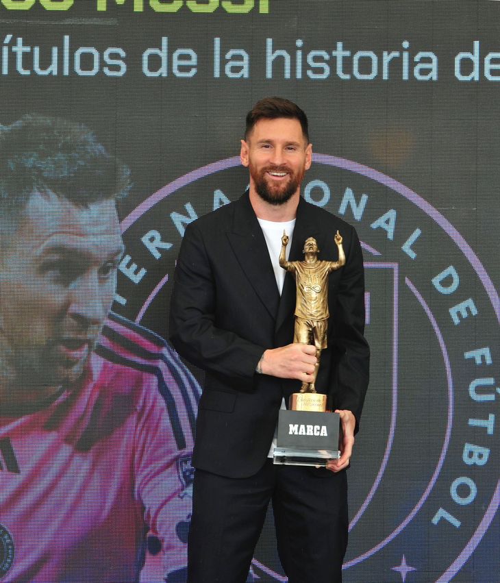 Lionel Messi posando junto a la escultura realizada por Carlos Benavídez.