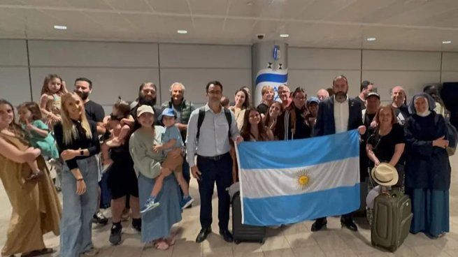 Los argentinos repatriados posan con la bandera nacional