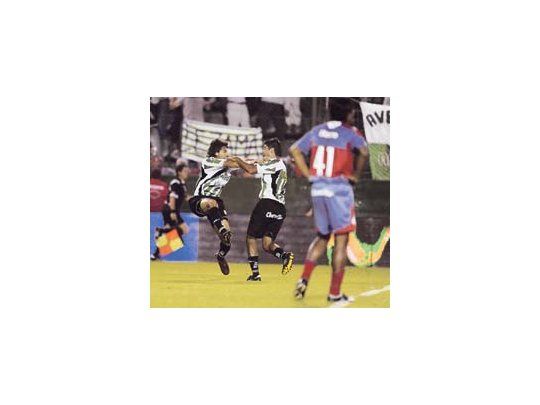 Víctor López salta de alegría para festejar su gol, mientras Barraza trata de abrazarlo; Néstor Ayala se lamenta. El Apertura se define el domingo.