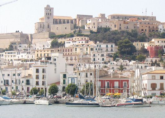 Las famosas y siempre muy concurridas playas bañadas por el Mediterráneo y  una vista donde puede observarse la Ciudad Vieja (Dalt Vila) encerrada en una muralla medieval que es hoy Patrimonio de la Humanidad.
