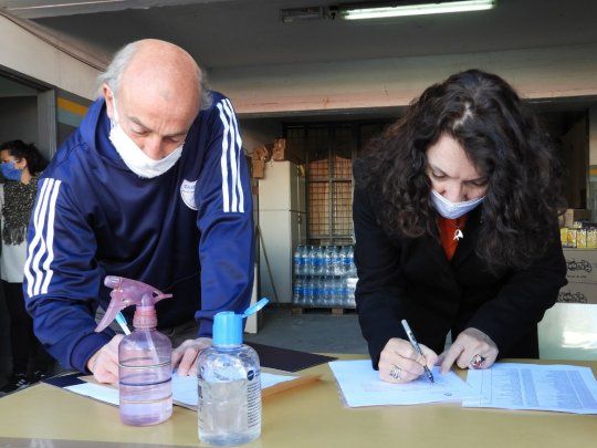 Cristina Caamaño, y el padre Lorenzo “Toto” De Vedia durante la firma del acuerdo.