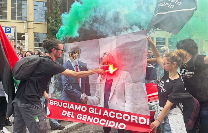 Protesters burn the photo with the images of the Prime