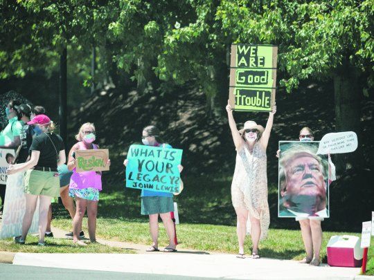 DESCONTENTO. Manifestantes adversos a Donald Trump se expresaron el fin de semana frente al complejo de golf de Virginia al que el presidente acudió a jugar.