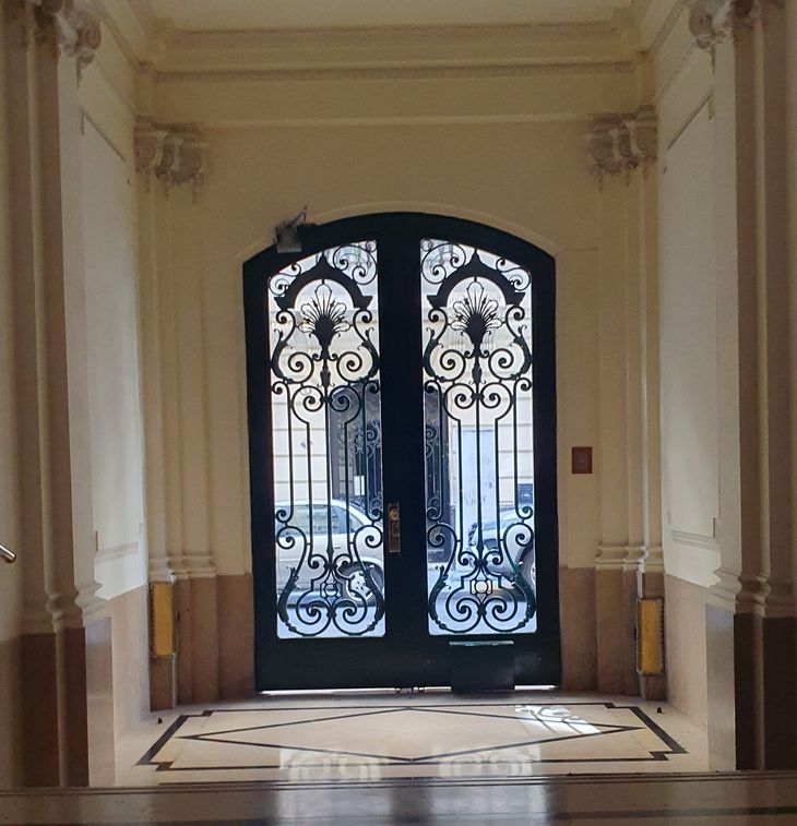 Acceso principal con herrería original y detalles de época, conservados en el interior del edificio