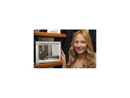 Noemí Letizia posa junto a una foto de Berlusconi