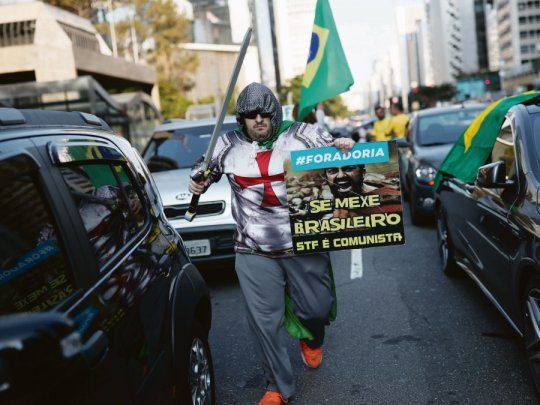 REACCIÓN. Simpatizantes de Jair Bolsonaro salieron ayer en Brasilia en una caravana de autos para manifestarle su respaldo. Todo Brasil percibe que se profundiza la crisis política.