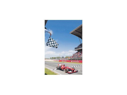 El español Fernando Alonso, a bordo de la Ferrari, recibe la bandera a cuadros que lo corona ganador del Gran Premio de España.