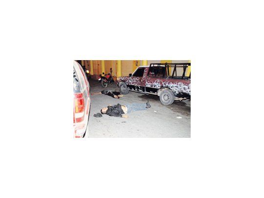 Dos hombres yacen muertos en una calle de la localidad mexicana de Tecalitlan. La creciente violencia ligada al narcotráfico se extiende hacia todo el territorio de ese país.