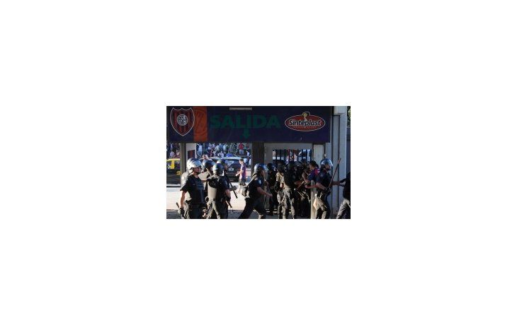 La policía intenta frenar a los hinchas luego del partido con Colón.