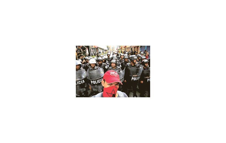ámbito.com | Un partidario del mandatario depuesto Manuel Zelaya, frente a polícias que bloqueaban ayer el acceso al Congreso.