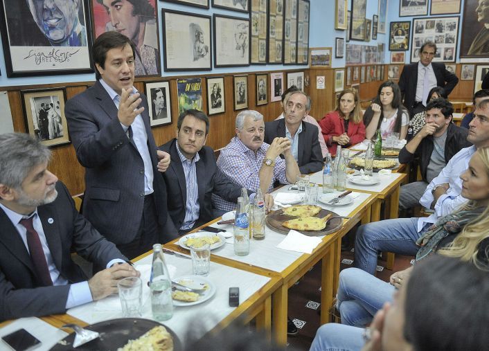 Recalde con deportistas y pizza.