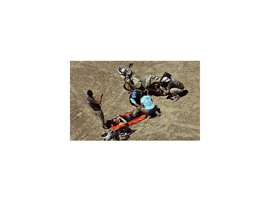 Uno de los pilotos siendo atendido al lado de su moto.