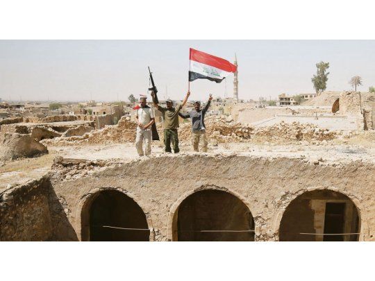 VICTORIA AGRIDULCE. Tras la ofensiva, los soldados ondearon la bandera iraquí. Tal Afar quedó en ruinas y llevará meses volver a reestablecer los servicios básicos.