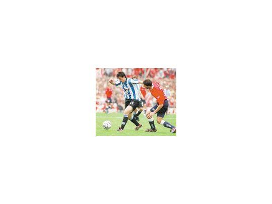 Diego Milito intenta escapar a la marca de Matías Manrique.