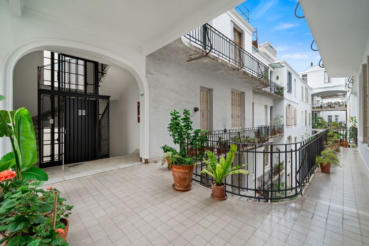 Balcones corridos y pasillos abiertos organizan la vida cotidiana del complejo, con barandas de hierro y macetas que aportan verde al conjunto Balcones corridos y pasillos abiertos organizan la vida cotidiana del complejo, con barandas de hierro y macetas que aportan verde al conjunto