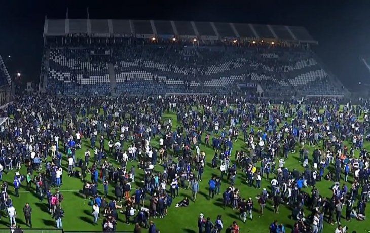 Suspendido. Los hinchas de Gimnasia terminaron dentro de la cancha, escapando de los gases lacrimógenos que tiró la policía.