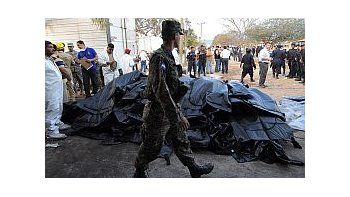 Un soldado custodia la montaña de cuerpos de los reos calcinados.