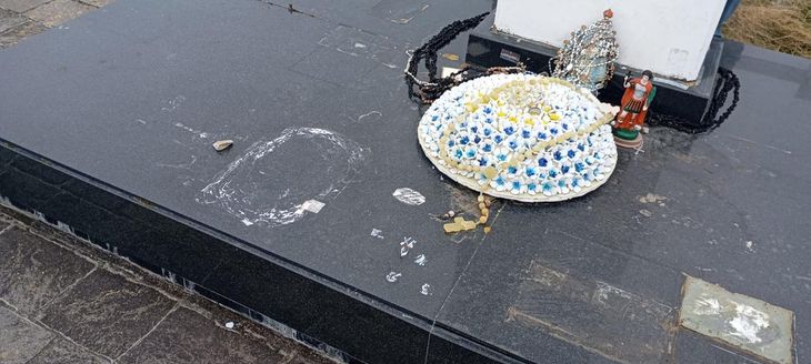 Las imágenes de placas, rosarios, cintas y figuras religiosas tiradas fuera del Cementerio Argentino de Darwin, en las Islas Malvinas.