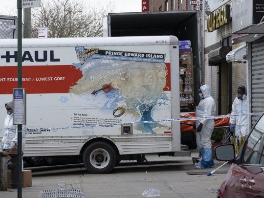 La policía de Nueva York mueve los cuerpos en descomposición de los camiones de mudanza.