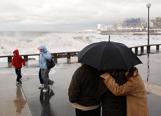 Numerosas personas se acercaban a la costa para ver los daños que causaron el viento y la pleamar de más de tres metros, en la costa.