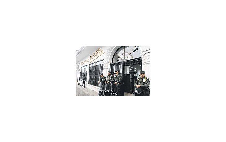 Efectivos de seguridad protegen la puerta de una financiera involucrada en un fraude de tipo piramidal en la ciudad colombiana de Popayán. Miles de personas estafadas protagonizan desde el miércoles violentos disturbios en varias ciudades.