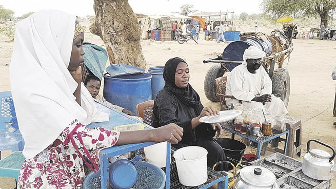HUÍDA. Una familia de refugiados sudaneses espera en la frontera con Chad luego de escapar del reciente estallido de violencia.