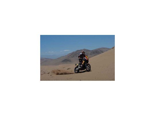 Coma con su KTM entre las dunas del desierto.
