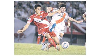 Mariano Pavone lucha con Juan Sabia. A River le faltó osadía y Argentinos se conformó con el empate. Hubo mucha lucha y poco fútbol.
