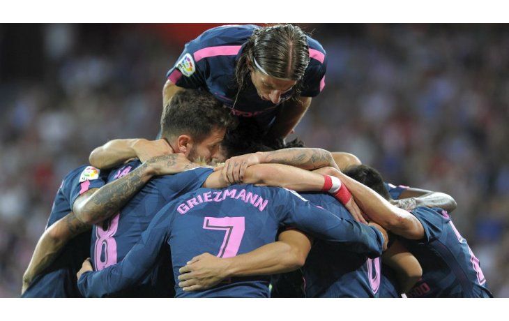 Los jugadores de Atlético de Madrid envuelven en un abrazo a Correa, quien abrió el marcador en el triunfo sobre Athletic Bilbao.