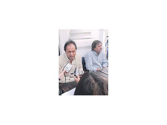 Daniel Scioli ayer en Tandil, junto a Néstor Auza, titular de la CIC. En torno al vice se desarrolla una disputa por quién será el compañero de fórmula.
