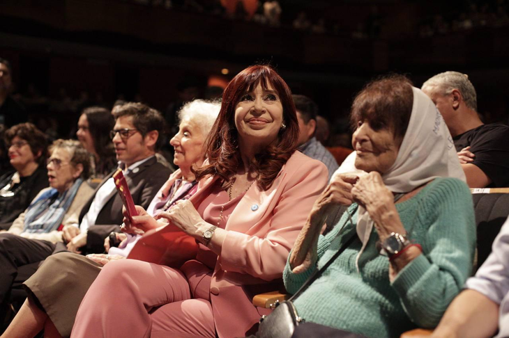 Cristina Kirchner sonriendo al público. En el fondo, Axel sonríe sin mirar a la expresidenta. Cristina Kirchner sonriendo al público. En el fondo, Axel sonríe sin mirar a la expresidenta.