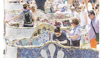 ámbito.com | Grupos de turistas recorren el Parque Gaudí, una de las principales atracciones de la ciudad. La nueva alcaldesa, Ada Colau, suspendió temporalmente la construcción de nuevos complejos hoteleros.