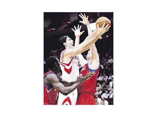 Luis Scola entre Jrue Holiday y Spencer Hawes. A pesar de la gran actuación del argentino, los Rockets cayeron ante Philadelphia.