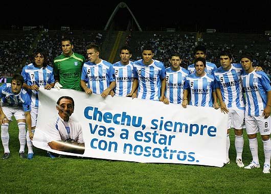 El equipo de Racing muestra la pancarta en homenaje a César Nardi, masajista fallecido a causa de un rayo.
