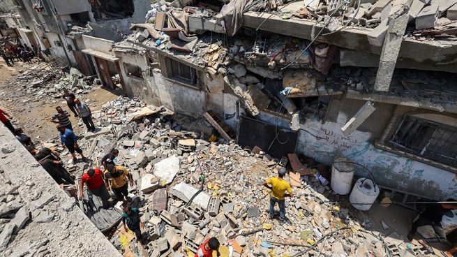 Gazatíes inspeccionan un centro de refugiados atacado por Israel el domingo.