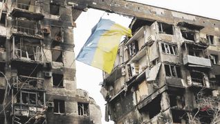 SÍMBOLO. Una bandera ucraniana flamea en un edificio en ruinas de la ciudad de Mariúpol. Bajo fuego casi desde el inicio de la guerra el 24 de febrero, esa localidad sufre una dramática crisis humanitaria.