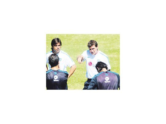 Julio César Falcioni les explica a los jugadores cómo quiere parar el equipo titular, mientras su ayudante Javier Sanguinetti escucha atentamente.