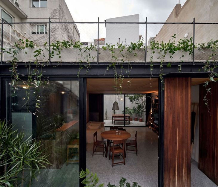 Casa modular implantada en un lote urbano, con estructura industrializada, grandes aberturas y conexión directa con un patio interior Casa modular implantada en un lote urbano, con estructura industrializada, grandes aberturas y conexión directa con un patio interior
