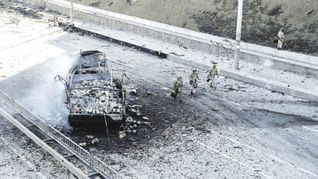 ALERTA. Soldados custodian uno de los ingresos de Kiev, mientras que imágenes satelitales muestran a un convoy militar ruso dirigiéndose a la capital ucraniana.