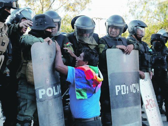 ruego. Un simpatizante de Evo Morales se arrodilla frente a un piquete policial durante una manifestaci&oacute;n en Cochabamba, una de las ciudades en las que m&aacute;s se ha sentido la represi&oacute;n.
